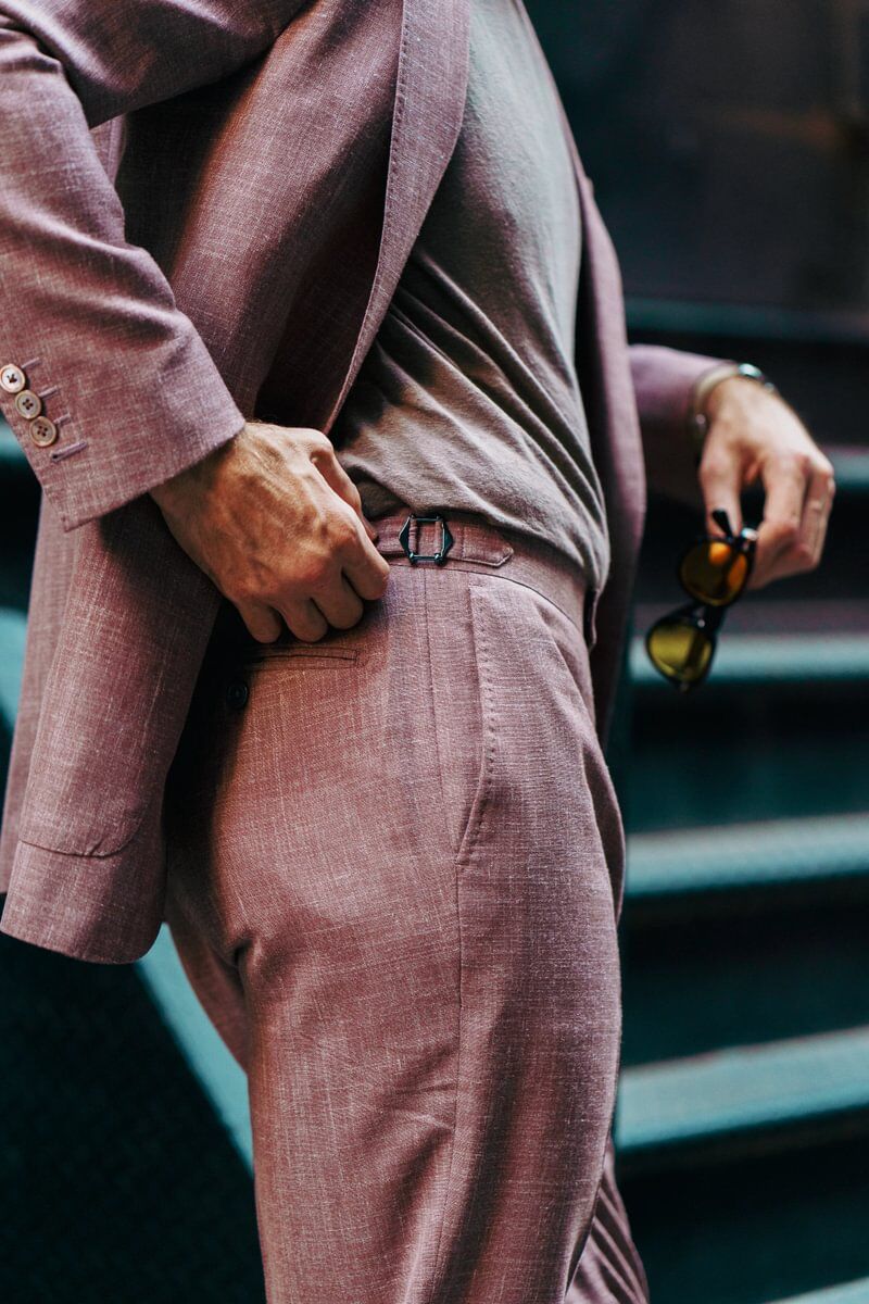 Close-up of a dusty rose blend suit with side adjuster detail, paired with a casual tee